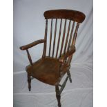 An old elm and beech spindle back kitchen carver chair with shaped seat on turned tapered legs