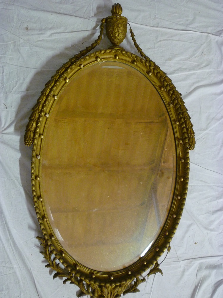A good quality 19th century bevelled oval wall mirror in ornate gilt frame with urn finial and
