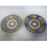 A pair of tin glazed circular plaques with painted floral decoration