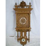 A large old Continental wall clock with circular dial and individual porcelain numerals in heavily