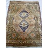 An Eastern hand knotted wool rug with geometric and floral decoration on red and blue ground 59" x