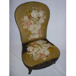 A Victorian mahogany easy chair upholstered in floral tapestry on turned  legs with castors