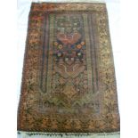 An old Eastern hand knotted wool rug with floral decoration on blue and red ground 57" x 36"