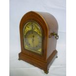 An old German bracket clock with silvered and gilt arched dial in inlaid mahogany arched case with