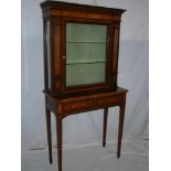 A late Victorian/Edwardian display cabinet with two drawers in the frieze, glass shelves enclosed by