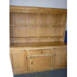 A large 19th century stripped and polished pine farmhouse dresser with central drawer and