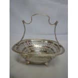 A George V silver square sweetmeat serving basket with pierced sides and scroll handle, Sheffield