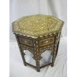 An old Middle Eastern octagonal centre table with bone inlaid floral top and arched folding base