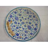 A large old Persian pottery circular charger with turquoise and blue floral and leaf decoration, 24"