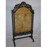 A large 19th century carved mahogany arched fire screen with needlework tapestry panel on bobbin