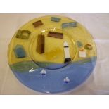 A Cornish St. Ives studio glass circular charger depicting a lighthouse, church tower and emblems by