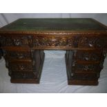 A Victorian carved oak rectangular desk with three drawers in the frieze and six pedestal drawers