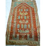 An old Eastern hand knotted wool prayer rug with geometric decoration on red ground 70" x 40"