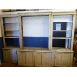 A George III painted pine break front bookcase, the base with cupboards enclosed by four panelled