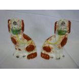 A pair of Victorian Staffordshire pottery seated spaniel figures with floral baskets and chained
