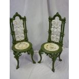 A pair of Victorian cast iron garden chairs with ornate scroll decorated backs and circular seats on