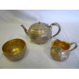 A Victorian silver three piece teaset comprising bullet-shaped teapot with engraved bird and