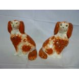 A pair of Victorian Staffordshire pottery seated spaniel figures with brown and white painted