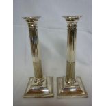 A pair of good quality electroplated Corinthian column candlesticks with fluted stems and square