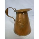 A large old beaten copper tapered jug with engraved daffodil decoration