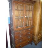 A 19th century oak narrow display cabinet, the base with two short and three long drawers with