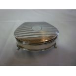 A George V silver semi-circular jewellery box with engine turned decoration on three scroll feet,