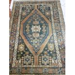 An Eastern hand knotted wool rug with geometric decoration on blue and brown ground 81" x 56"