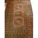 A 20th century Eastern wool rug with geometric decoration on red ground 72" x 50"