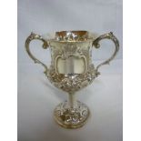 A Victorian silver two handled pedestal trophy cup with raised floral decoration and circular