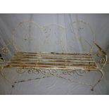 An old painted metal and wirework three seat garden bench with arched back on scroll supports