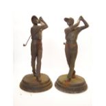A pair of cast iron golfers on circular