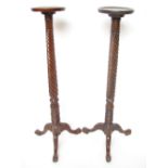 A near pair of mahogany torchere stands,