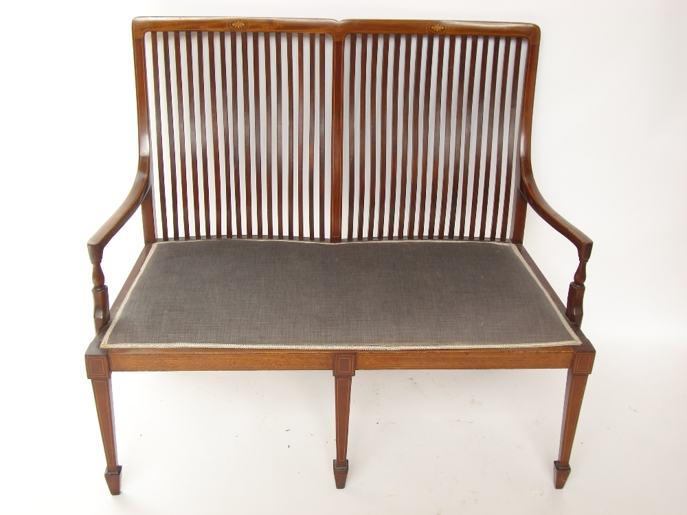 An Edwardian mahogany and marquetry inlaid settee, with slatted back,