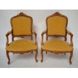 A pair of early 20th Century French Louis XV style fruitwood armchairs,