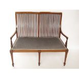 An Edwardian mahogany and marquetry inlaid settee, with slatted back,