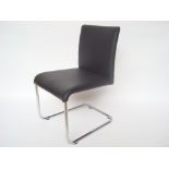A Hulsta contemporary chromed tubular steel cantilever chair, upholstered in black leather.