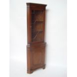 A George III style mahogany free standing corner display cabinet,