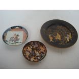 Three Japanese dishes to include a satsuma black ground dish decorated in gold with figures in a
