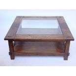 A Lombok teak square low table, the top inset with glass with undertier.