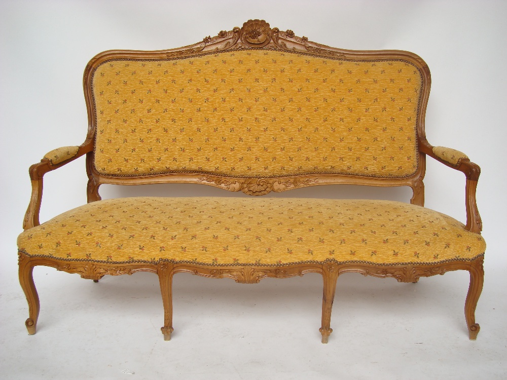 An early 20th Century French Louis XV style walnut settee, with moulded and leaf carved frame,