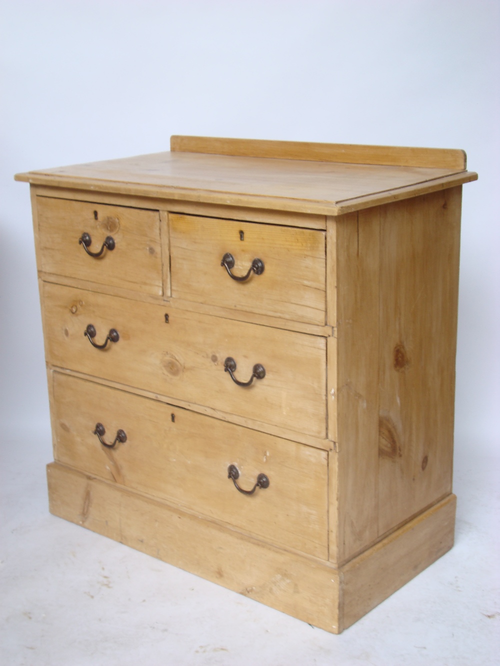 An Edwardian small pine chest of drawers, with two short and two graduated long drawers,