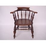 An early 20th Century smokers beech and elm bow armchair, with turned spindle back and solid seat,