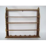 An Edwardian oak hanging plate rack with barley twist uprights.