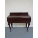 A 19th Century mahogany hall table the raised back over two end drawers with rising leaf on carved