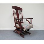 An American walnut rocking chair with line carved detail and turned decoration, on iron base