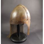 A Norman replica "Nasal" helmet with chain mail neck piece, on a display stand