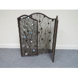 A bronzed metal three fold fire screen with abalone shell roundels