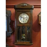 An oak cased wall clock, Arabic numerated dial, three train 8-day movement, key and pendulum