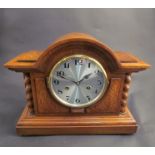 An oak mantel clock with barley twist columns, silvered Arabic numerated dial, 8-day movement