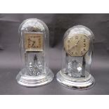 Two anniversary clocks in glass domes